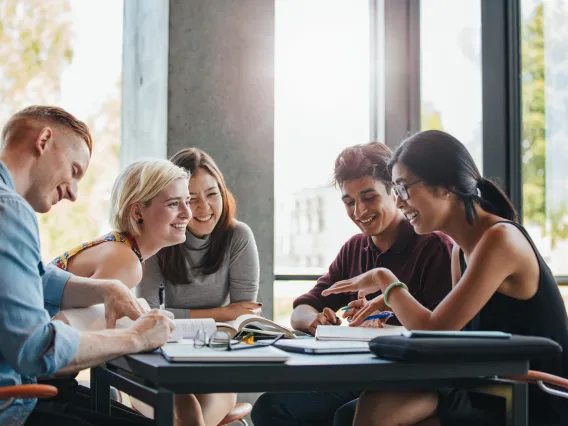 A diversity of students on a table working on a project