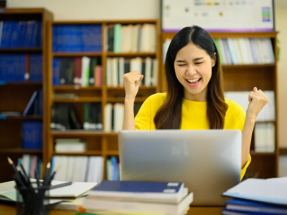 Student celebrating looking at a computer