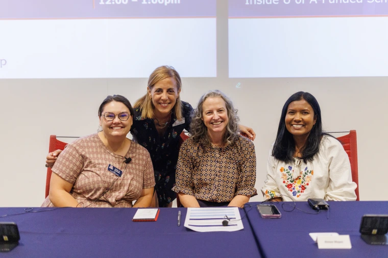 Dr. Guada Lozano (standing) poses with panelists (sitting, from left) Dr. Emily Jo Schwaller, Dr. Aimee Mapes, and Dr. Amritha Wickramage.