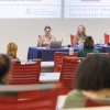Three women sit at a panel table during a University of Arizona presentation on writing assignments.
